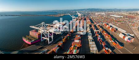 Vista aerea sul porto esterno di Oakland. Carrelli carichi che si muovono da gru a container. Foto Stock