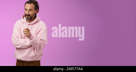 Uomo carismatico e carismatico in elegante felpa con cappuccio rosa invitandoli ad unirsi all'azienda sorridente auto-assicurato indicando che il selezionamento fa Foto Stock