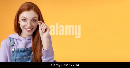 Affascinante sciocco modesto giovane redhead femminile ginek gioco amante discus ultime tendenze di gioco sorridendo felice divertito occhiali touch grinning curioso ricezione Foto Stock