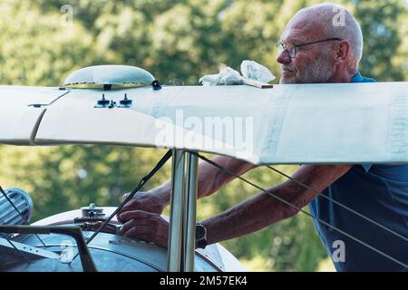 Un volontario che preparerà un biplano Nieuport 28 francese d'epoca per una rappresentazione di rievocazione bellica all'American Heritage Museum. Hudson, Massachuse Foto Stock