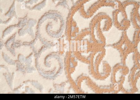 Frammento di tessuto decorativo tappeto, texture foto di sfondo. Primo piano dell'ornamento geometrico di tappeti a pelo corto beige e bianco. Concetto di sfondi e texture. Foto Stock