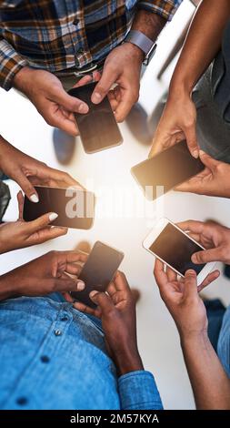 Rimanete vicini, restate connessi. un gruppo di persone che utilizzano i propri smartphone in sincronia. Foto Stock