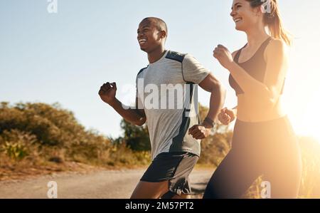 Ogni miglio vale la pena. una giovane coppia in forma che va per una corsa all'aperto. Foto Stock