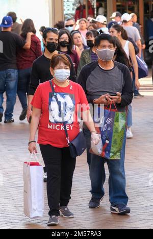 Los Angeles, California, Stati Uniti. 26th Dec, 2022. Gli amanti delle vacanze che indossano maschere facciali trasportano borse presso il Citadel Outlets di Commerce, California, lunedì, dicembre. 26, 2022. (Credit Image: © Ringo Chiu/ZUMA Press Wire) Foto Stock