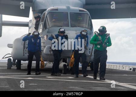 OCEANO PACIFICO (18 novembre 2022) — i marinai rimuovono i cunei e le catene che fissano un Osprey MV-22 assegnato a Marine Medium Tiltrotor Squadron (VMM) 362 prima di decollare dal molo di trasporto anfibio USS Anchorage (LPD 23), 18 novembre 2022. La capacità di operare in modo fluido e simultaneo sul mare, a riva e in aria rappresenta il valore unico della capacità anfibia fornita dal gruppo anfibio pronto e dal team Marine Exipitionary. La Makin Island ARG, composta da nave d'assalto anfibio USS Makin Island (LHD 8) e bacini di trasporto anfibi Anchorage e USS John P. Murtha (LHD 26) Foto Stock