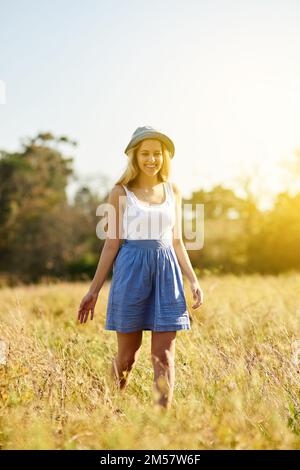 Trascorrere il tempo in natura aumenta la felicità. una giovane donna su un albero si stoppa in campagna. Foto Stock