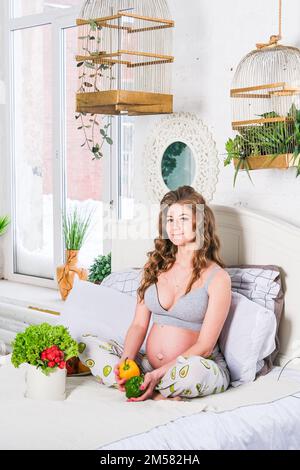 alimentazione sana e gravidanza. pancia della donna incinta e insalata di verdure Foto Stock