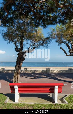 Arcachon, nella Gironda, Francia. Una delle famose panchine rosse della località balneare, qui di fronte alla baia di Arcachon Foto Stock