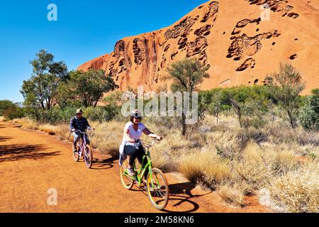A cavallo di una bicicletta intorno Uluru Ayers Rock. Territorio del Nord. Australia Foto Stock