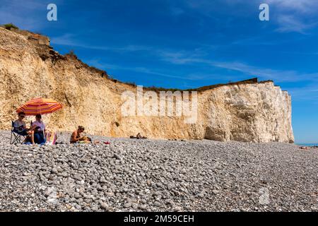 Inghilterra, East Sussex, Eastbourne, The Seven Sisters Cliffs, The Birling Gap, Famiglia con Parasol colorato rilassante sulla spiaggia *** Caption locale *** UK Foto Stock