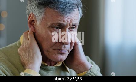 Triste vecchio uomo caucasico soffrono di dolore al collo 60s disturbi maschio stanco nonno sentire dolore nella colonna vertebrale male fastidio tensione sfregamento muscolo da Foto Stock