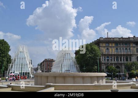 Fontana senza acqua nella piazza del Castello Sforzesco di Milano. Le principali sedi temporanee di EXPO Milano 2015 sullo sfondo in una giornata di sole estivo. Foto Stock