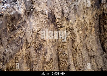 La tessitura del suolo di creta nella fossa dopo lavoro di escavatore. La struttura dei footprint della benna dell'escavatore. Foto Stock