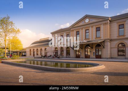 Una vista panoramica della stazione ferroviaria di Zwolle con il sole appena visibile dietro di essa Foto Stock