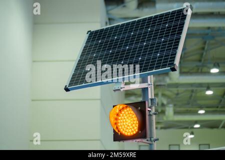 Semaforo a LED singolo arancione alimentato da pannelli solari in mostra - primo piano Foto Stock