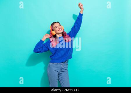 Ritratto di buon umore ottimista donna carina indossare cuffie maglia pullover ballare divertirsi isolato su sfondo vivace colore teal Foto Stock