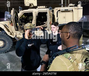 Il Senior Airman Adrien Kahmchanh prova un casco in una mostra dell'unità di smaltimento dell'ordinanza esplosiva dell'Ala 380th durante una Career Expo presso la base aerea di al Dhafra, Emirati Arabi Uniti, 13 febbraio 2022. Watch is Airman 1st Class Rian Harrell. Tecnico. John Mitchell, dell’unità EOD, ha fornito agli Airmen informazioni sulle operazioni e sulle attrezzature dell’EOD. L'expo ha permesso al personale assegnato alla base di acquistare e commerciare patch di unità e di conoscere molti dei campi di carriera che esistono sulla base. Foto Stock