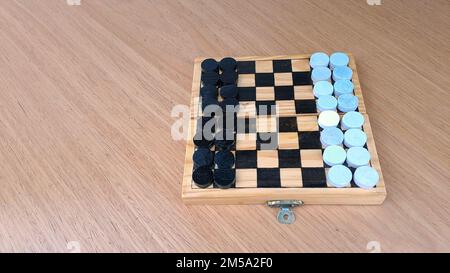 Scacchiera con dama - Pianificazione di strategia di affari. Scacchiera in plastica su tavolo di legno marrone Foto Stock