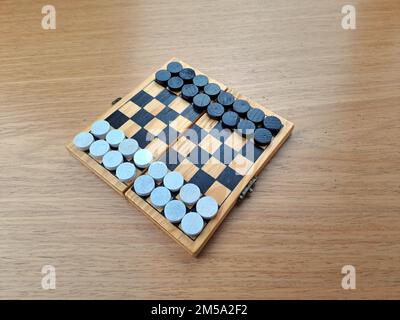 Scacchiera con dama - Pianificazione di strategia di affari. Scacchiera in plastica su tavolo di legno marrone Foto Stock