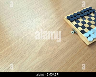 Scacchiera con dama - Pianificazione di strategia di affari. Scacchiera in plastica su tavolo di legno marrone Foto Stock