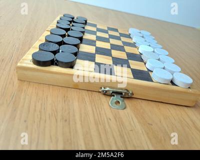 Scacchiera con dama - Pianificazione di strategia di affari. Scacchiera in plastica su tavolo di legno marrone Foto Stock