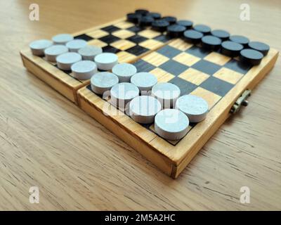 Scacchiera con dama - Pianificazione di strategia di affari. Scacchiera in plastica su tavolo di legno marrone Foto Stock