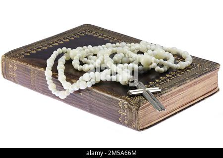 rosario su libro di preghiera comune vintage isolato su sfondo bianco Foto Stock