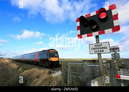 Attraversare il paese C2C 170110 Turbostar passando un unmanned passaggio a livello vicino Manea, Cambridgeshire, Inghilterra. Foto Stock