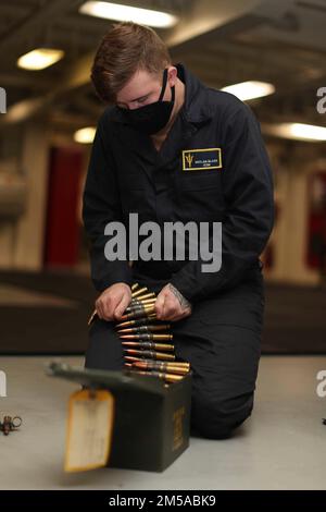 220215-N-TT639-1077 OCEANO PACIFICO (15 febbraio 2022) – comunicazione interna l'elettricista Seaman Declan Black, di Greenville, N.Y., organizza munizioni a bordo della nave d'assalto anfibia USS Tripoli (LHA 7), 15 febbraio. Tripoli sta conducendo operazioni di routine nella U.S. 3rd Fleet. Foto Stock