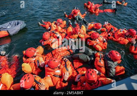 Water Survival Training i partecipanti aspettano il loro turno per salire a bordo di un velivolo simulato il 15 febbraio 2022 a Hurlburt Field, Florida. La formazione è condotta da specialisti di Survival, Evasion, Resistance e Escape che istruiscono il personale di volo su come navigare in sicurezza in un atterraggio d'acqua. Foto Stock