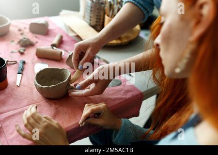 Lezione di laboratorio di ceramica. Un piatto di ceramica artigianale da una creta cruda. Creazione di ceramiche Foto Stock