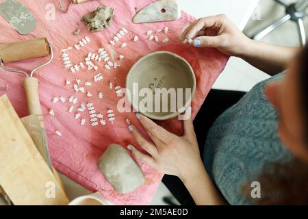 Primo piano immagine delle mani femminili opere con argilla rende futuro piastra in ceramica, classi di costruzione a mano in laboratorio di ceramica moderna, Creative People Foto Stock