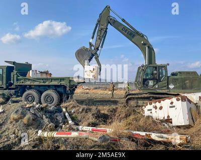 220215-N-KT522-1008 Iwakuni, Giappone. (FEBBRAIO 15, 2022) Battaglione Navale per le costruzioni mobili (NMCB) 3, Battaglione di supporto tecnico 9th e Squadrone di supporto delle ali marine 172 funzionano come unità coesiva per rimuovere le barriere in metallo/cemento utilizzando l'ESCAVATORE 250g e il dumper MTVR MK30. NMCB-3 viene implementato nella regione dell'Indo-Pacifico, conducendo una costruzione di alta qualità per supportare gli Stati Uniti e le nazioni partner a rafforzare la partnership, scoraggiare l'aggressione e consentire la logistica di spedizione e le proiezioni del potere navale. Il battaglione è pronto a completare il compito assegnato, sostenere aiuti umanitari/disastri Foto Stock