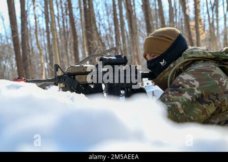 Un difensore assegnato allo Squadrone delle forze di sicurezza del 926th, con sede presso la base dell'aeronautica di Nellis, Nevada, tiene traccia di una persona non identificata nel bosco, mentre tiene pronto il fucile del M4 durante un esercizio di difesa statica al Camp James A. Garfield Joint Military Training Center, Ohio, 15 febbraio 2022. L'esercizio faceva parte del corso sulla leadership della difesa integrata, un'intensa esperienza di apprendimento pratica di due settimane, progettata per aiutare i difensori della Reserve a raggiungere e mantenere la preparazione al combattimento. (STATI UNITI Foto Air Force/Eric M. White) Foto Stock