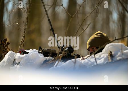 Un difensore assegnato allo Squadrone delle forze di sicurezza del 926th, con sede presso la base dell'aeronautica di Nellis, Nevada, tiene traccia di una persona non identificata nel bosco, mentre tiene pronto il fucile del M4 durante un esercizio di difesa statica al Camp James A. Garfield Joint Military Training Center, Ohio, 15 febbraio 2022. L'esercizio faceva parte del corso sulla leadership della difesa integrata, un'intensa esperienza di apprendimento pratica di due settimane, progettata per aiutare i difensori della Reserve a raggiungere e mantenere la preparazione al combattimento. (STATI UNITI Foto dell'aeronautica/staff Sgt. Noah J. Tancer) Foto Stock