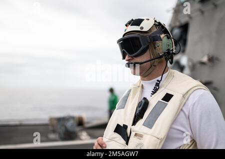 220216-N-LI768-1021 MARE DELLE FILIPPINE (16 febbraio 2022) – Mate Brandon Fischer, capo di Boatswain, di Edmond, Oklahoma, osserva le operazioni di volo come ufficiale del ponte di volo a bordo della nave litoranea da combattimento USS Tulsa (LCS 16), variante dell'Indipendenza. Tulsa, parte di Destroyer Squadron (DESRON) 7, è su un dispiegamento rotazionale, che opera nell'area delle operazioni della flotta degli Stati Uniti 7th per migliorare l'interoperabilità con i partner e servire come una forza di risposta pronta a sostegno di una regione indomPacifico libera e aperta. Foto Stock