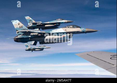 Tre Stati Uniti Air Force F-16 Fighting Falcons assegnato al 18th Aggressor Squadron, volare accanto a un 909th Air Refuelling Squadron KC-135 Stratotanker sopra l'Oceano Pacifico a sostegno di Cope North 22, 16 febbraio 2022. Lo Squadrone Aggressor prepara le forze aeree di combattimento, gli equipaggi aerei congiunti e alleati attraverso la stimolante e realistica replica delle minacce, la formazione, il supporto ai test, gli accademici e il feedback. Foto Stock