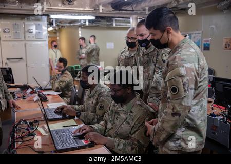 I soldati assegnati al primo corpo americano e gli Airmen assegnati al Joint Communications Support Element, eseguono controlli di comunicazione sulla città di Bismarck dell'USNS presso la base navale Guam, 16 febbraio 2022. I membri del servizio stanno testando le capacità di comunicazione per migliorare la prontezza, mostrare l'interoperabilità congiunta ed esercitare il comando di missione distribuito nel Pacifico. Foto Stock