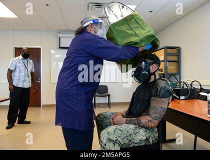 FORT WORTH, Texas (16 febbraio 2022) - Joint Service Mask Leakage Tester Arnie Perez, Center, esegue un test di adattamento della maschera a gas M-50 per la Riserva della Marina Yeoman 1st Classe Andre Polk, assegnata al Navy Reserve Center New York City, al comando di preparazione e mobilitazione della Regione della Riserva della Marina Fort Worth (REDCOM FW), in preparazione della prevista mobilitazione della Polk in Qatar. Il trattamento di mobilizzazione delle riserve selezionato per Polk e altri marinai ha avuto luogo durante un evento di attivazione della mobilizzazione adattativa presso IL REDCOM FW dal 14 al 18 febbraio. L'evento è stato osservato dai valutatori del Centro di preparazione al combattimento Expeditionary, Foto Stock