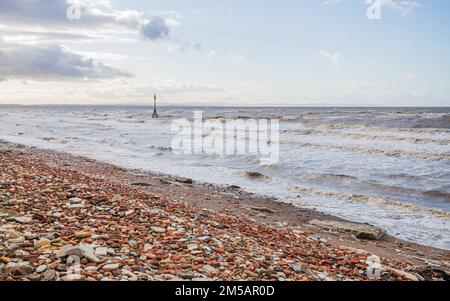 Le onde si schiantano sui mattoni rossi che fiancheggiano parte della spiaggia a Crosby vicino a Liverpool il giorno di Santo Stefano nel 2022. Foto Stock