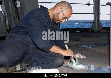 MARE DELLE FILIPPINE (17 febbraio 2022) il compagno di Boatswain, Seaman Miguel Soberal, di Hatillo, Porto Rico, dipinge un occhio sul fantasma a bordo della portaerei di classe Nimitz USS Abraham Lincoln (CVN 72). Abraham Lincoln Strike Group è in fase di implementazione pianificata nell'area delle operazioni della flotta 7th degli Stati Uniti per migliorare l'interoperabilità attraverso alleanze e partnership e al tempo stesso fungere da forza di risposta pronta a sostegno di una regione indomPacifico libera e aperta. Foto Stock