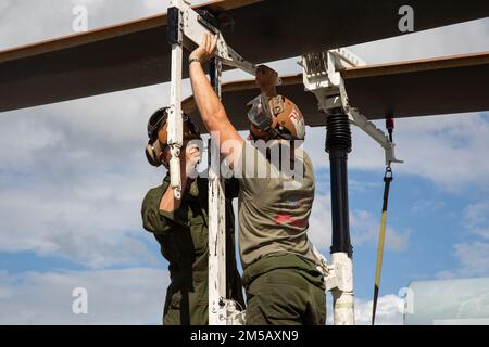 STATI UNITI Hunter Weldon, destra, meccanica aerea con Marine Light Attack Squadron (HMLA) 367, prepara gli elicotteri UH-1Y Venom e AH-1Z Viper il trasporto in California come parte di Deployment for Training (DFT) alla base navale Pearl Harbor, Hawaii, 16 febbraio 2022. Il DFT viene deisgned per simulare il funzionamento in un ambiente distribuito e preparare l'unità a eventuali imprevisti futuri che potrebbero incontrare durante l'implementazione. Foto Stock