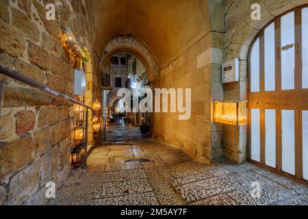 Gerusalemme, Israele - 24 dicembre 2022: Vicolo nel quartiere ebraico della Città Vecchia, con vari Menorah tradizionali (lampade Hanukkah) con olio d'oliva Foto Stock