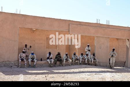 Niger Armed Forces (lingua francese: Forces Armées Nigeriennes) i membri guardano le loro controparti alla ricerca di un veicolo durante un evento di addestramento alla base aerea nigeriana 201, Agadez, Niger, 17 febbraio 2022. Trenta FAN hanno ricevuto formazione dai 409th consulenti aerei dello Squadrone delle forze di sicurezza espeditarie su varie tattiche per rafforzare le loro capacità di difesa e migliorare le minacce contro-transnazionali. La formazione insieme ai nostri partner africani crea relazioni strategiche e crea la fiducia operativa per unire le forze in modo coeso in qualsiasi momento e ovunque. Foto Stock