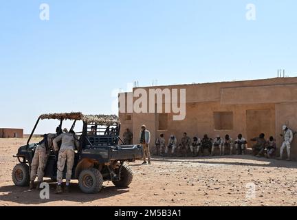 Due membri delle forze armate del Niger (lingua francese: Forze armate nigeriennes) cercano un veicolo mentre le loro controparti guardano durante un evento di addestramento alla base aerea nigeriana 201, Agadez, Niger, 17 febbraio 2022. Il 409th ESFS ha ospitato un corso di otto settimane per addestrare i 30 FAN membri su varie tattiche come le abilità salvavita di combattimento, manovre di armi, ricerche di veicoli e movimenti di pattuglia per contrastare meglio l'escalation violenta estremismo nella regione a tre confini del Niger, Burkina Faso e Mali. Foto Stock