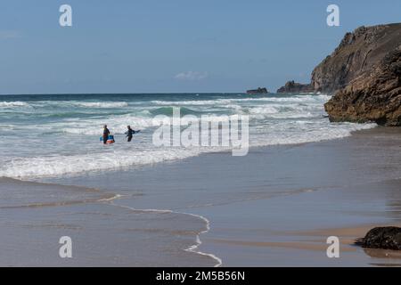 Padstow, Cornovaglia regno unito Settembre, 06 2012 un paio di surfisti che si dirigono verso il mare per navigare, piccolo in cornice, spazio copia, Foto Stock