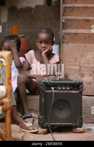 Carina ragazza africana seduta accanto ad un ampli per chitarra a Bamako , Mali , Africa Occidentale Foto Stock