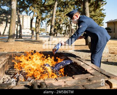 Airman First Class Anthony Paree, 8th Fighter Wing base Honor Guardsman, mette una bandiera americana ritirata in un fuoco cerimoniale alla base aerea di Kunsan, Repubblica di Corea, 18 febbraio 2022. La squadra della guardia d'onore di base si ritirò e bruciò nove bandiere durante la cerimonia. Foto Stock