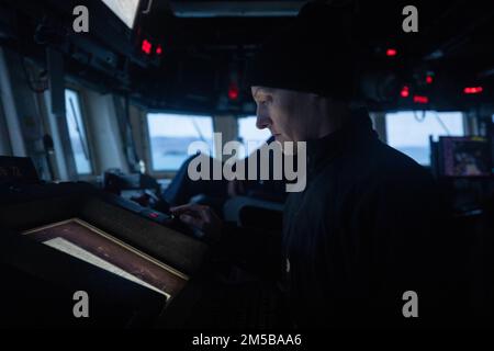 OCEANO ATLANTICO (18 febbraio 2022) – Lt. CMdR. Cassie Redner controlla il Voyage Management System sul ponte del cacciatorpediniere missilistico guidato USS Donald Cook (DDG 75), 18 febbraio. Donald Cook è schierato nel teatro europeo delle operazioni e partecipa a una serie di attività marittime a sostegno della flotta degli Stati Uniti 6th e degli alleati della NATO. Foto Stock