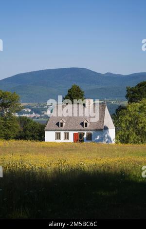 Vecchio regime francese 1752 legno bianco tavola con cedro scandole tetto casa stile cottage in estate, Saint-Francois, Ile d'Orleans, Quebec, Canada. Foto Stock